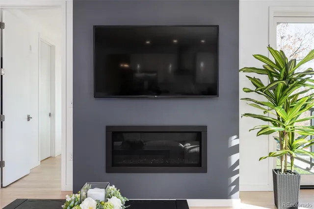 a living room with a fireplace and a potted plant