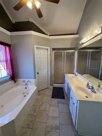 a bathroom with a tub a sink and a large mirror
