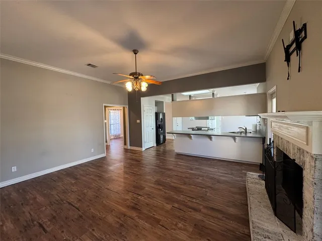 an empty room with a chandelier fan and windows