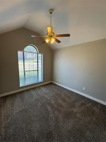 en empty room with windows and chandelier fan