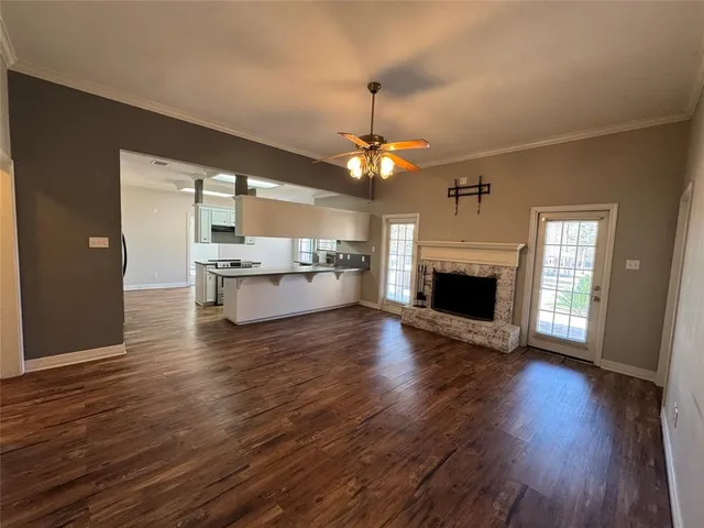 a living room with stainless steel appliances granite countertop a fireplace a flat screen tv and a fireplace