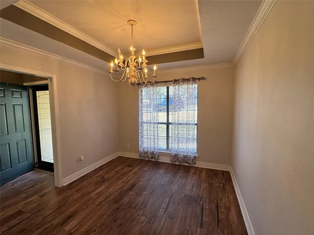 a view of an empty room with wooden floor fireplace and a window
