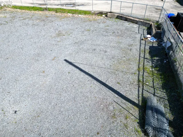 a view of a dry yard with wooden fence