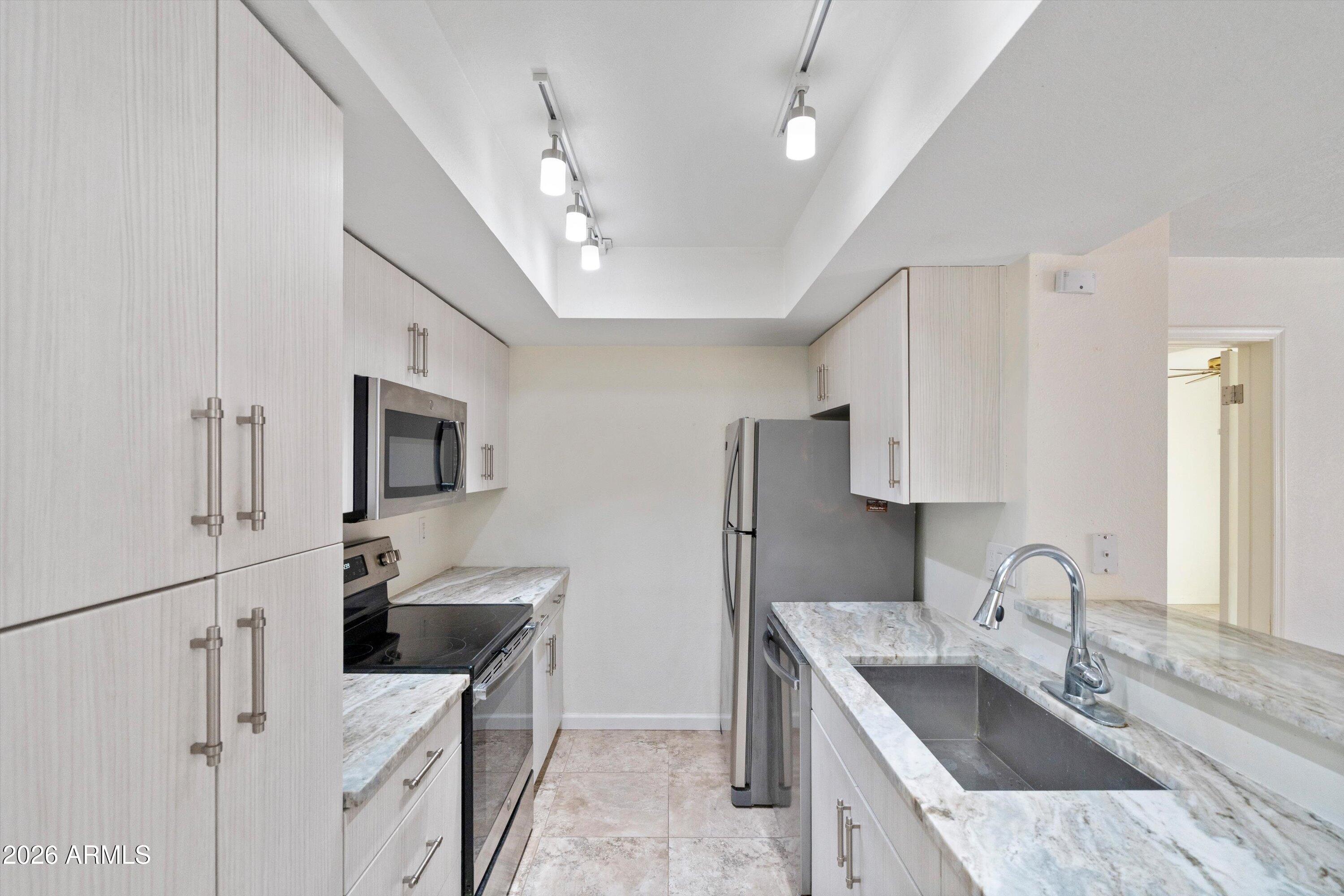 10410 North Cave Creek Road, Unit 1031 Phoenix, AZ 85020 - Photo 11 of 28 a kitchen with stainless steel appliances granite countertop a sink stove and refrigerator