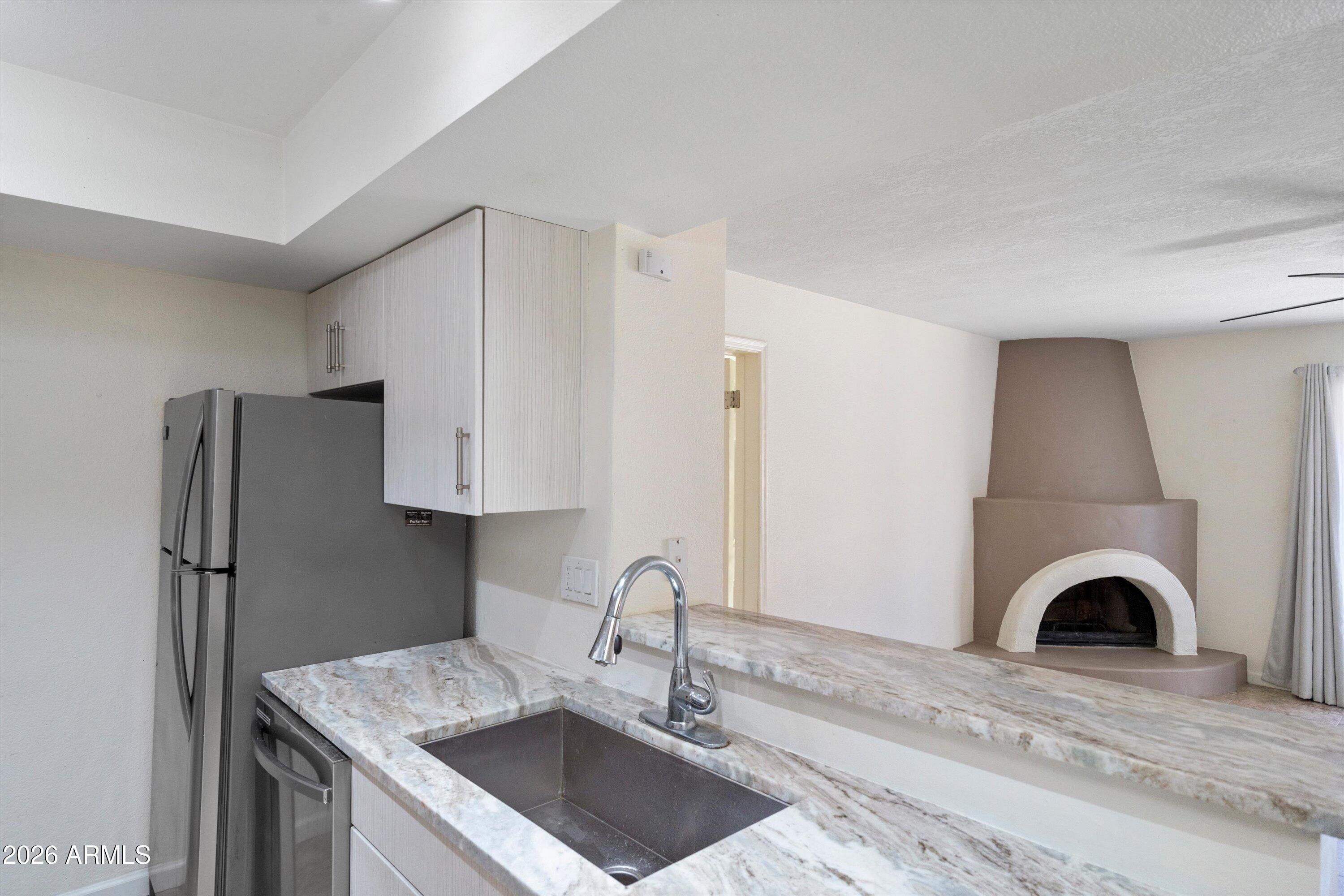 10410 North Cave Creek Road, Unit 1031 Phoenix, AZ 85020 - Photo 12 of 28 a kitchen with granite countertop a sink a refrigerator and a stove
