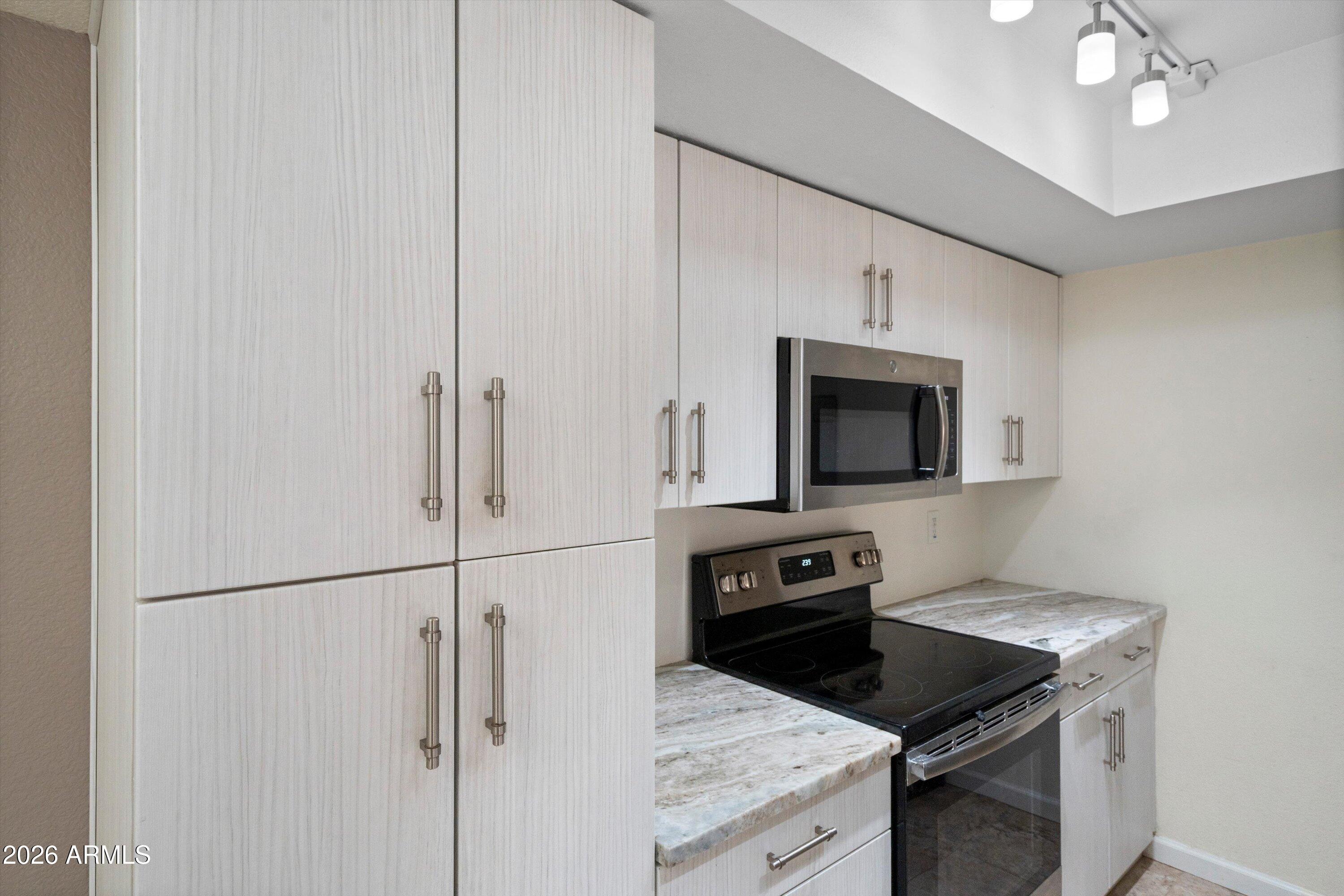 10410 North Cave Creek Road, Unit 1031 Phoenix, AZ 85020 - Photo 13 of 28 a kitchen with a stove and a microwave