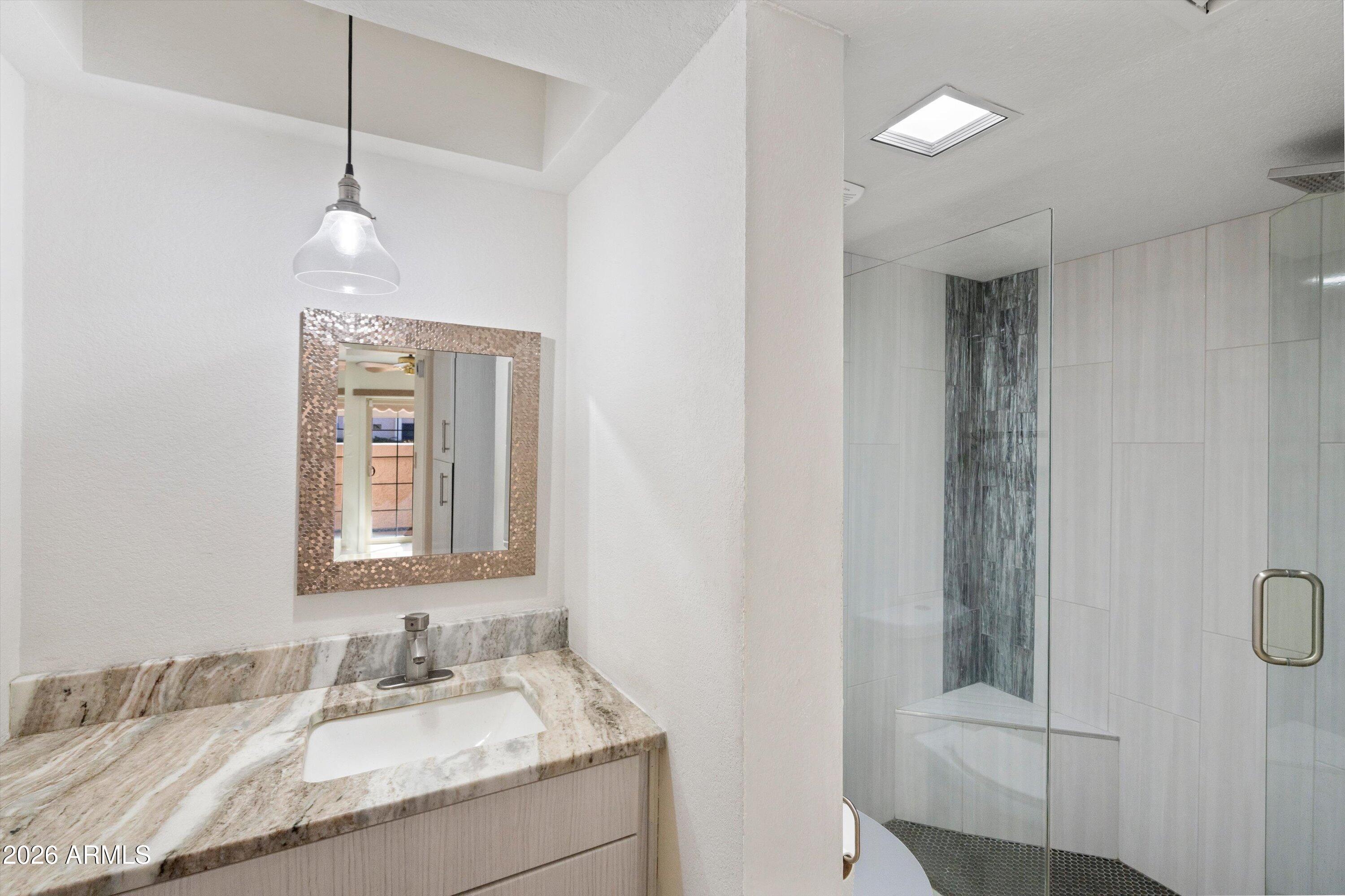 10410 North Cave Creek Road, Unit 1031 Phoenix, AZ 85020 - Photo 16 of 28 a bathroom with a granite countertop sink a mirror and shower