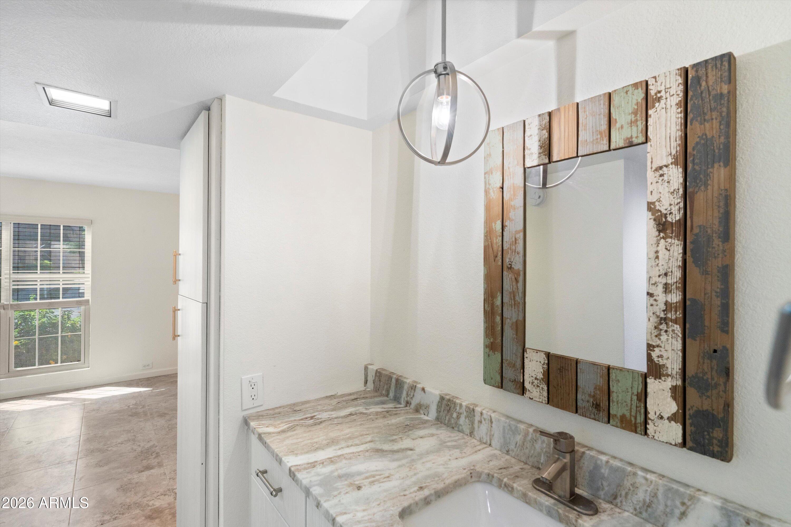 10410 North Cave Creek Road, Unit 1031 Phoenix, AZ 85020 - Photo 22 of 28 a bathroom with a granite countertop shower a mirror and a sink