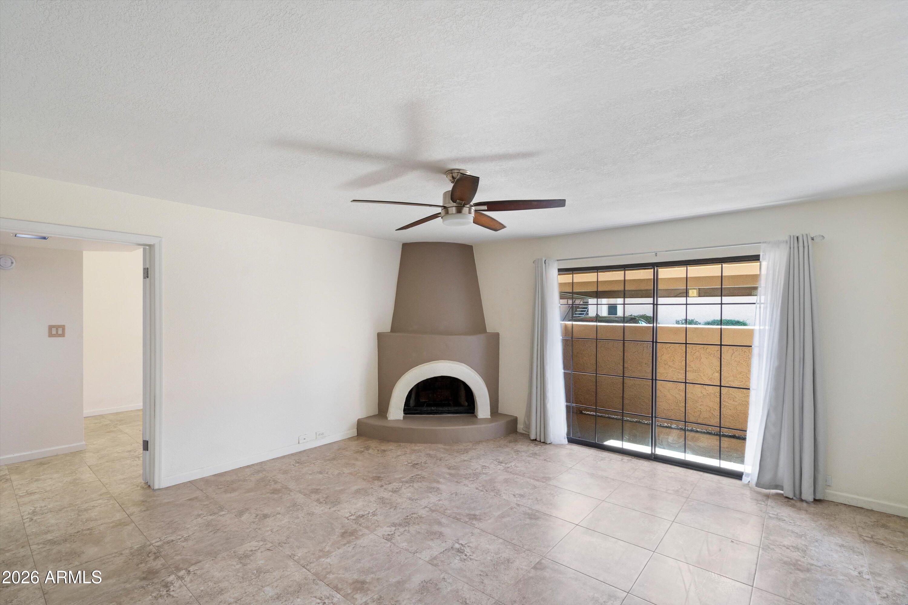 10410 North Cave Creek Road, Unit 1031 Phoenix, AZ 85020 - Photo 5 of 28 a view of empty room with windows and fireplace