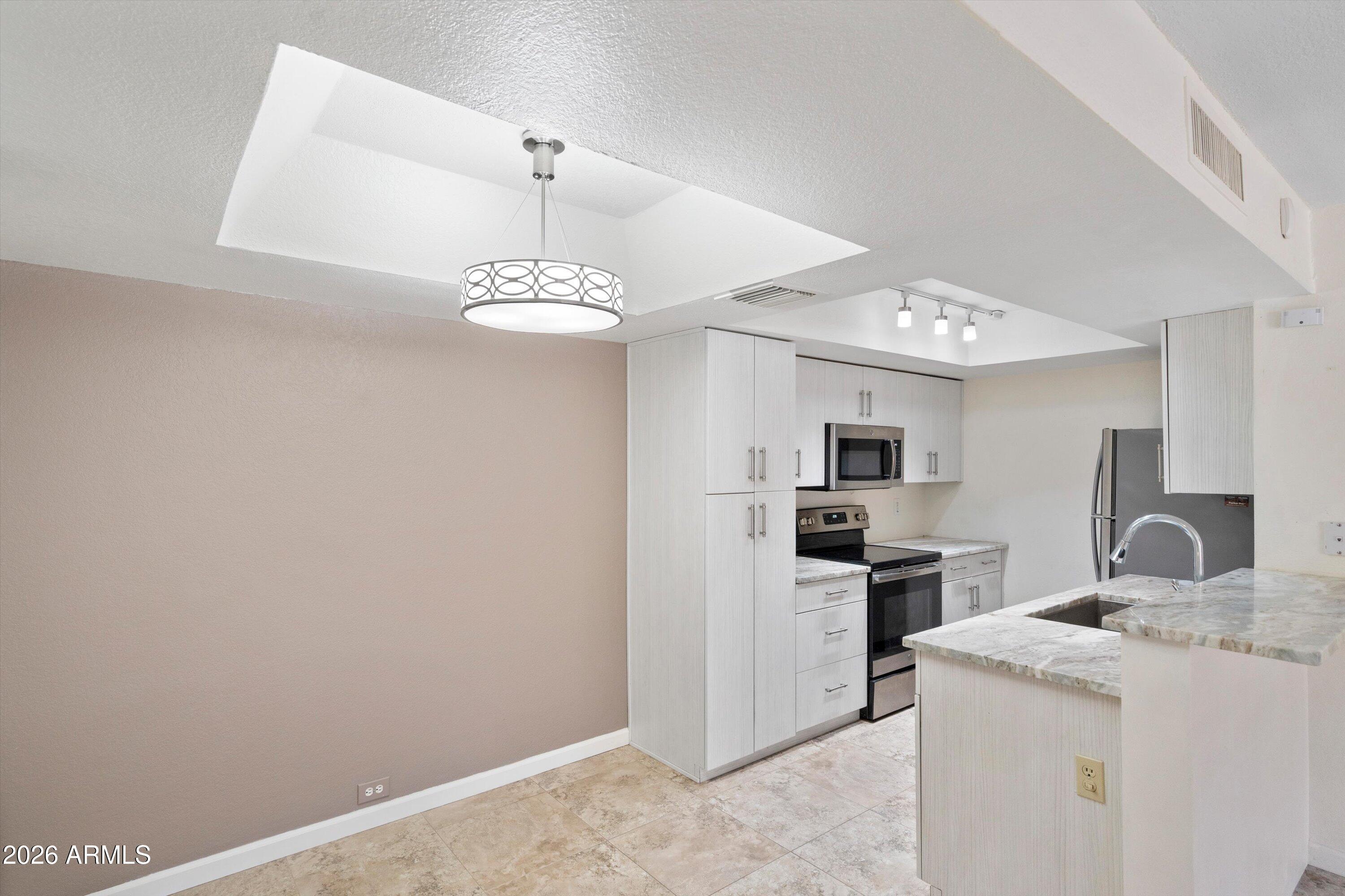 10410 North Cave Creek Road, Unit 1031 Phoenix, AZ 85020 - Photo 8 of 28 a kitchen with a stove and a refrigerator