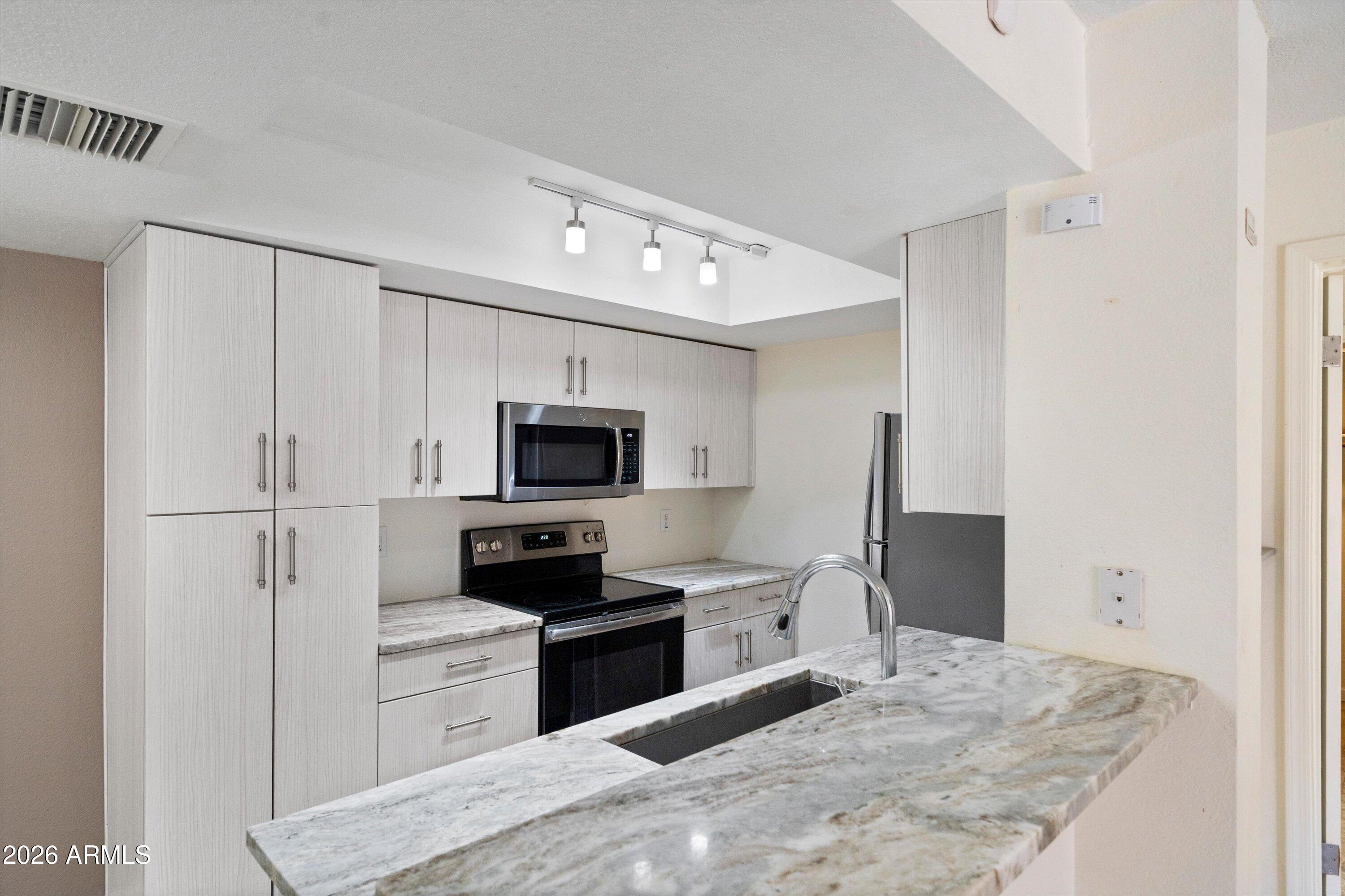 10410 North Cave Creek Road, Unit 1031 Phoenix, AZ 85020 - Photo 10 of 28 a kitchen with a refrigerator stove and microwave