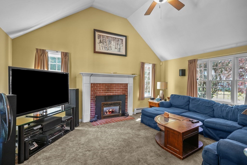 2 Commons Drive Carver, MA 02330 - Photo 13 of 37 a living room with furniture a flat screen tv and a fireplace