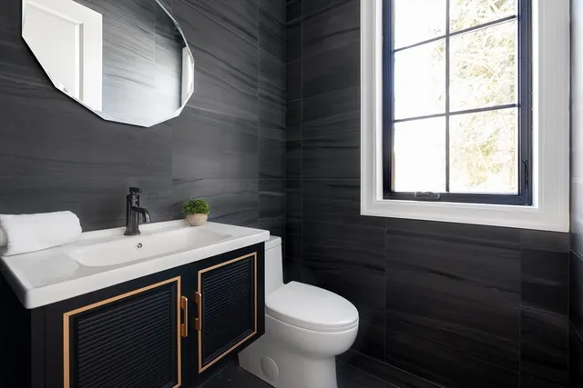 a bathroom with a sink a toilet and mirror