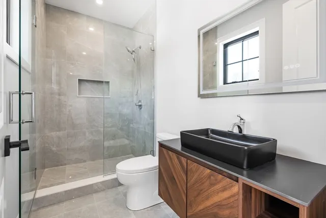 a bathroom with a sink a toilet and shower