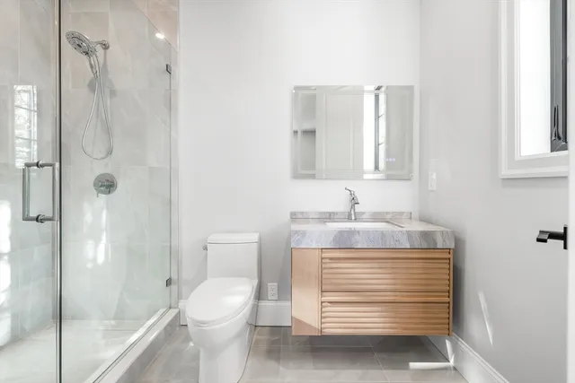 a bathroom with a granite countertop sink toilet a shower and a mirror