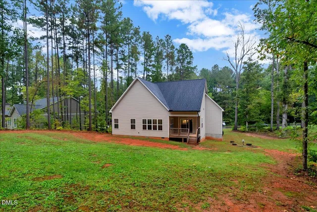 a view of a house with backyard and trees