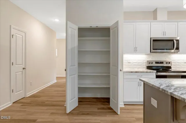 a kitchen with granite countertop a refrigerator and a stove top oven