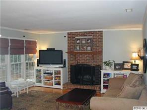 9815 Park Spring Charlotte, NC 28210 - Photo 7 of 15 a living room with furniture a fireplace and a flat screen tv