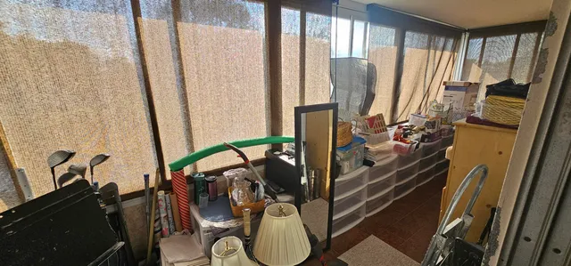 a view of a workspace with furniture and a window