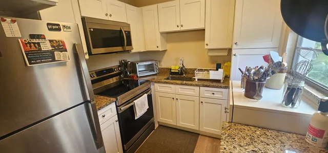 a kitchen with stainless steel appliances a refrigerator a sink a stove a microwave a sink and cabinets