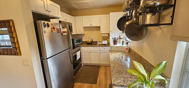 a kitchen with stainless steel appliances granite countertop a refrigerator stove and sink