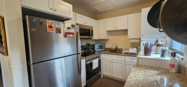 a kitchen with a refrigerator and a stove top oven