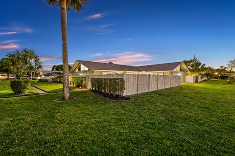 a view of a house with backyard and sitting area