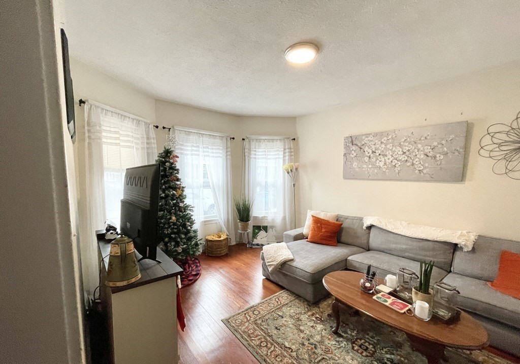 19 Eastman Street, Unit 1 Boston, MA 02125 - Photo 2 of 6 a living room with furniture and a wooden floor