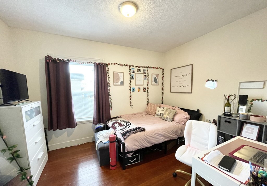19 Eastman Street, Unit 1 Boston, MA 02125 - Photo 3 of 6 a bedroom with a bed and wooden floor