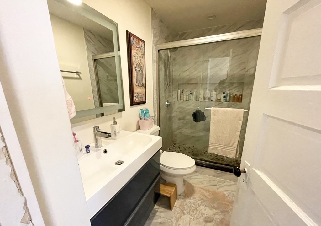 19 Eastman Street, Unit 1 Boston, MA 02125 - Photo 5 of 6 a bathroom with a sink a toilet and shower