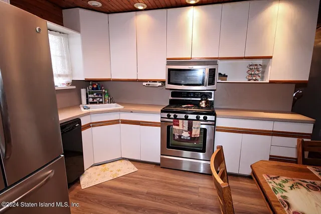 a kitchen with stainless steel appliances a microwave a sink and a refrigerator
