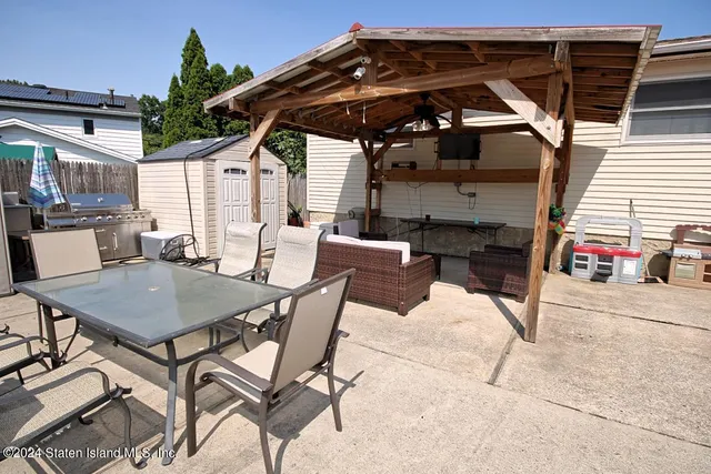 a view of patio with table and chairs under an umbrella
