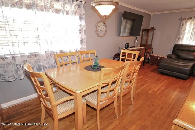 a dining room with furniture and a large window