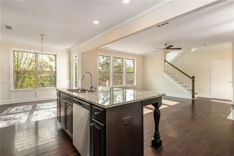 a kitchen with stainless steel appliances granite countertop a sink a stove and wooden floor