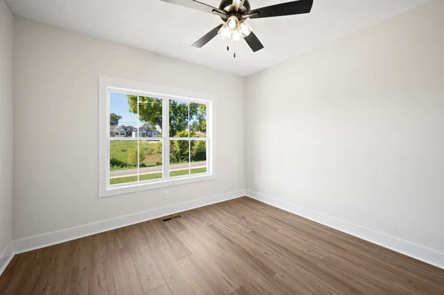 a view of a room with wooden floor and windows