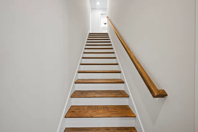 an empty room with windows and ceiling fan