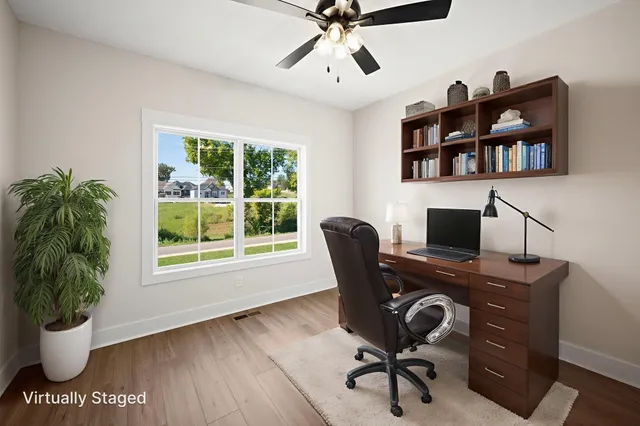a view of a workspace with furniture and a window