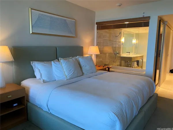 a large bed sitting in a bedroom next to a window