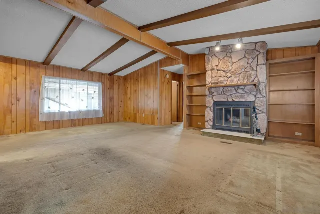 a view of an empty room with a fireplace and a window