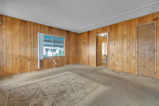 a view of an empty room with a window and doors