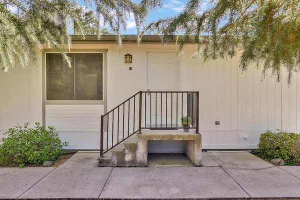 a view of a porch with a bench and wooden fence