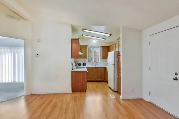 a view of kitchen with refrigerator and wooden floor