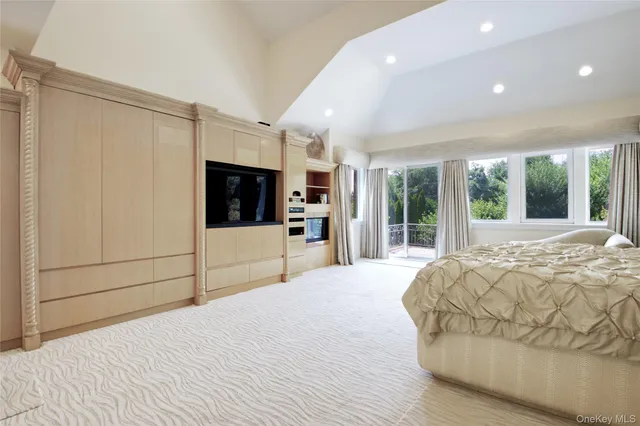 a large bedroom with a bed and a flat screen tv