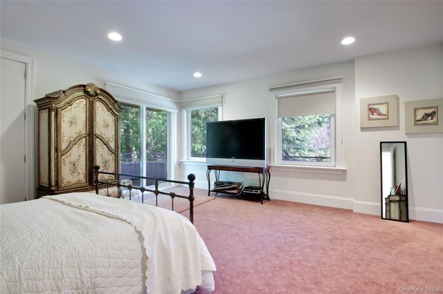 a bedroom with a bed and large windows