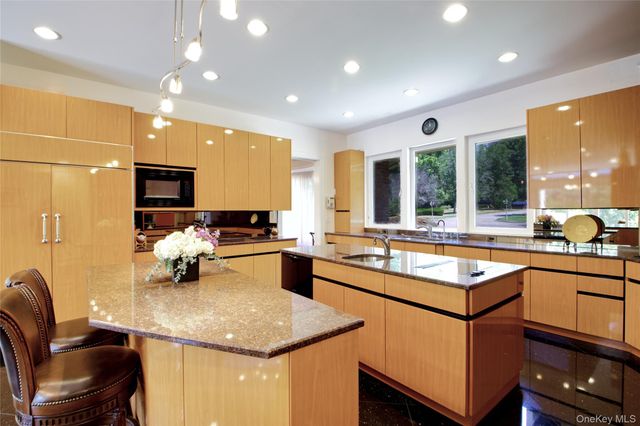 a kitchen with a sink stove and chairs