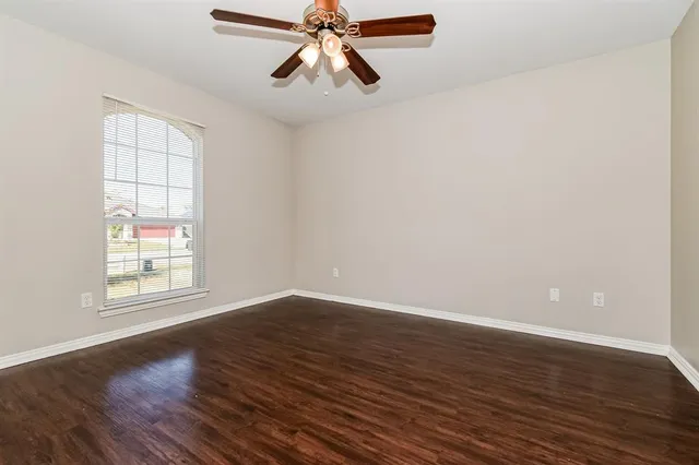 wooden floor in an empty room with a window