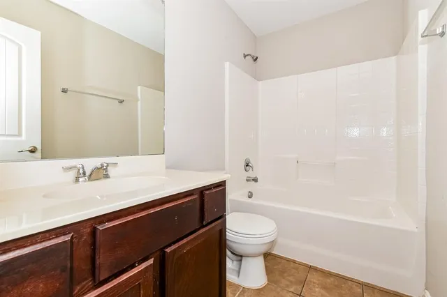 a bathroom with a granite countertop sink a toilet and shower