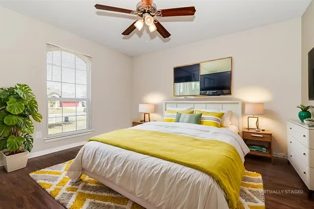 a bedroom with a bed a flat screen tv and a chandelier
