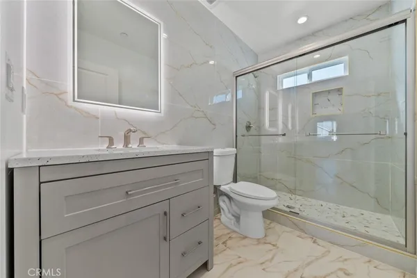 a bathroom with a shower sink vanity and toilet