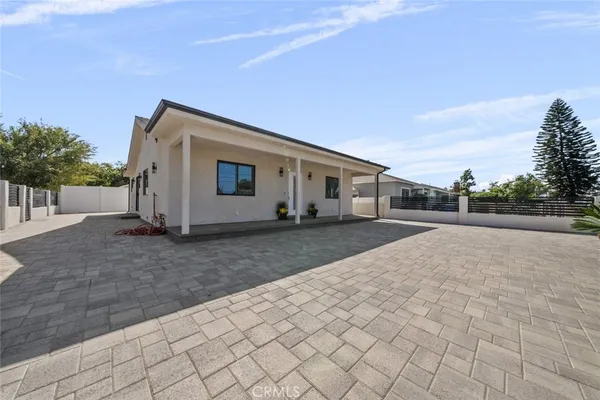 a view of house with backyard and trees in the background
